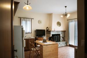 cocina con nevera, mesa y chimenea en Feels like home apartment in Zagora en Zagora