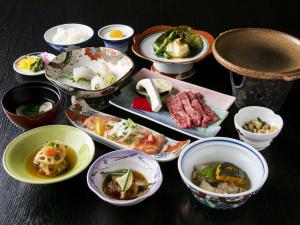 a table topped with bowls of different types of food at Hatsuneso Shinkan in Ureshino