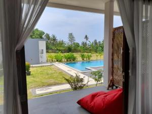 Habitación con ventana y vistas a la piscina. en Tree Tops Mandalika, en Kuta Lombok