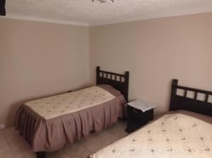 a bedroom with two beds and a trash can at Hostal Aramayo in Tupiza +35 photos