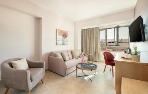 a living room with a couch and chairs and a tv at M City Hotel in Chania Town