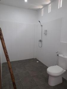 a bathroom with a toilet and a shower at Tree Tops Mandalika in Kuta Lombok