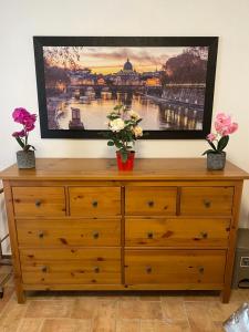 een televisie op een dressoir met bloemen erop bij castiglione apartament You&Me in Castiglione in Teverina