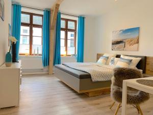 a bedroom with blue curtains and a bed in it at Apartment EIRA am Schleswiger Dom in Schleswig