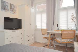 a bedroom with a tv and a table with chairs at Ferienwohnung Koje in zentraler Lage zum Schleswiger Dom in Schleswig