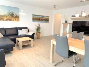 ein Wohnzimmer mit einem Sofa und einem Tisch in der Unterkunft Ferienwohnung Freyja Hafenspitze Eckernförde in Eckernförde