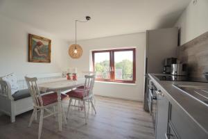a kitchen with a table and chairs in a room at Ferienwohnung - Unterm Dach in Schleswig