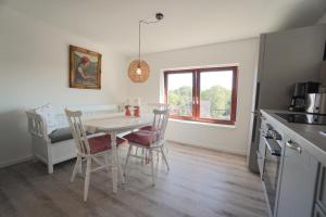 a kitchen and dining room with a table and chairs at Ferienwohnung - Unterm Dach in Schleswig +26 photos