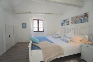 a bedroom with a white bed with blue and white pillows at Ferienwohnung - Unterm Dach in Schleswig