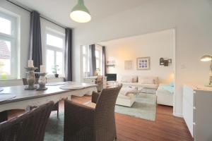 a dining room and living room with a table and chairs at Ferienwohnung Sprotte am Schleswiger Dom in Schleswig