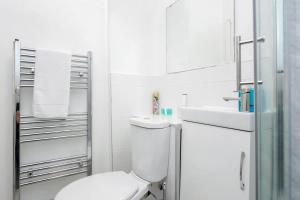 a white bathroom with a toilet and a sink at Stunning 1-Bed Apartment in London Lewisham in London