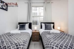 two beds sitting next to each other in a bedroom at Stunning 1-Bed Apartment in London Lewisham in London