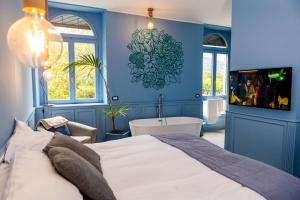a blue bedroom with a bed and a bath tub at Bello!Lake Como Suites in Como