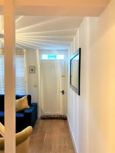 ein Wohnzimmer mit einem blauen Sofa und einer Tür in der Unterkunft Riverside Channel5 "Holidays Homes in the Sun" Featured Central Canterbury Cottage with Free Parking in Canterbury