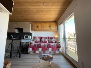 a bedroom with a bed and a kitchen with a balcony at residence les Ravieres 1 in La Toussuire