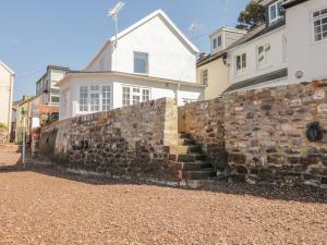 a stone wall in front of a house at Searles in Lympstone