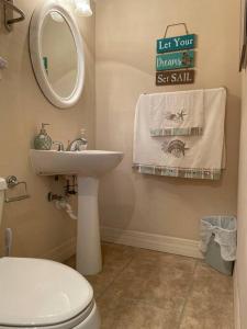 W łazience znajduje się umywalka, toaleta i lustro. w obiekcie Adorable private 1-bedroom studio on mini-farm. w mieście Providence
