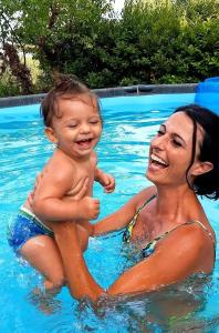 une femme tenant un bébé dans une piscine dans l'établissement Granducato di Monteballante, à Pesaro