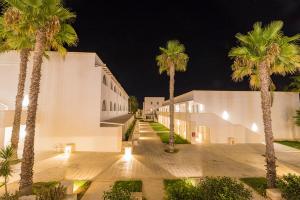 a group of palm trees in front of a building at HOTEL BARONE DI MARE in Torre dell'Orso