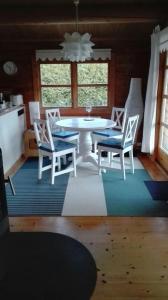 a dining room with a white table and chairs at Das blaue Häuschen in Westerholz
