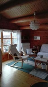 a living room with chairs and a couch and windows at Das blaue Häuschen in Westerholz