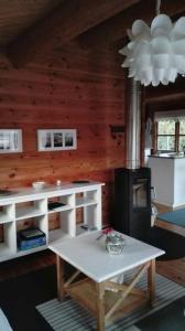 a living room with a table and a stove at Das blaue Häuschen in Westerholz