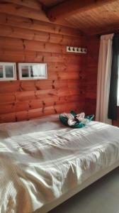 a bed in a wooden room with shoes on it at Das blaue Häuschen in Westerholz