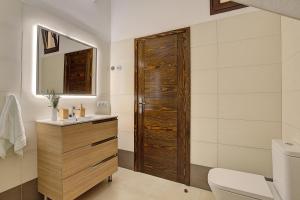 a bathroom with a wooden door and a sink at Elita Apartment in Los Llanos de Aridane +19 photos