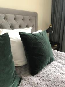 a bed with two green pillows on top of it at Apartamenty Vincent Sopot in Sopot +36 photos