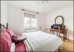 a bedroom with a bed and a desk and a window at 4 Bedroom Fisherman's Cottage in Norfolk in Cromer