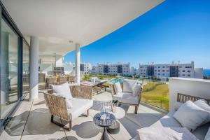 a balcony with white furniture and a view of the city at HigueronRentals Casa Kiki in Málaga