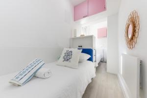 Dormitorio blanco con cama azul y blanca en Apartments Zajc, en Trogir