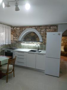 a kitchen with a white refrigerator and a table at Apartment Balinovaca in Skradin