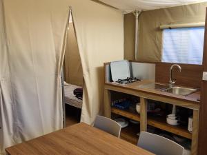 ein Raum mit Waschbecken und Tisch in einem Zelt in der Unterkunft camping les rives du lac in Bois Morin