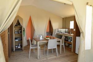 ein Esszimmer mit einem Tisch und Stühlen in einem Zelt in der Unterkunft camping les rives du lac in Bois Morin
