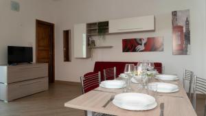 Un comedor con una mesa con platos y copas de vino. en Casa Dei Lecci - Cala Gonone, en Cala Gonone