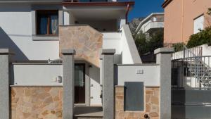 una casa blanca con un muro de piedra en Casa Dei Lecci - Cala Gonone, en Cala Gonone