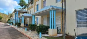 a row of houses with blue columns on a street at Esprit caraïbes in Le Diamant