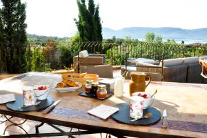 una mesa con comida en la parte superior de un patio en CASA SOPRANA - HAUT DE VILLA indépendant avec piscine et jardin privés - Independant TOP OF VILLA with private pool and garden, en Porto Vecchio