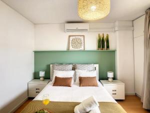 フンシャルにあるFantastic Apartment Marina Clubのベッドルーム(緑のヘッドボード付きの大きな白いベッド1台付)