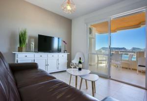 salon z kanapą, telewizorem i stołem w obiekcie Apartamentos Rubino (13º-B) w mieście Calpe