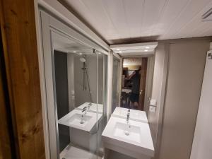 ein Badezimmer mit zwei Waschbecken und einem Spiegel in der Unterkunft camping les rives du lac in Bois Morin + 29 Fotos