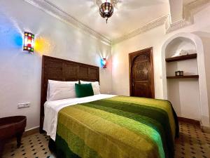 a bedroom with a bed with a green and yellow blanket at Kasba blanca in Tangier