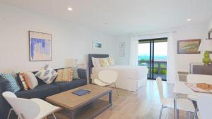 Una sala de estar con un sofá, una mesa y sillas. en Beachcomber Resort at Montauk, en Montauk