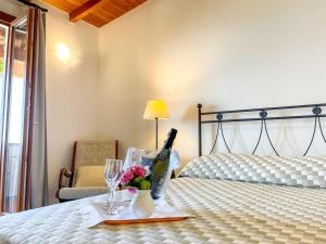 a bedroom with a bed with a bottle of wine and flowers at Il Capanno in Pietra Ligure