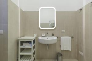 uma casa de banho com um lavatório e um espelho em Contempora Apartments - Cavallotti 13 - B23 em Milão