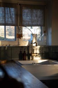 cocina con fregadero y 2 ventanas en Le Roi des Oiseaux - Gîte à la campagne, en Montcavrel