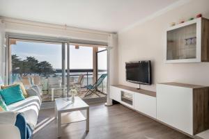 a living room with a couch and a tv at Face Mer appartement pour 4 personnes in Pornic