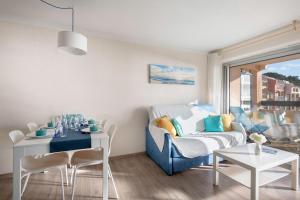 a living room with a blue couch and a table at Face Mer appartement pour 4 personnes in Pornic