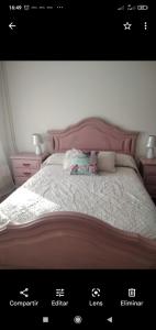 a bed with a pink headboard and pillows on it at Pozo das Leiras-izquierda- in Ares
